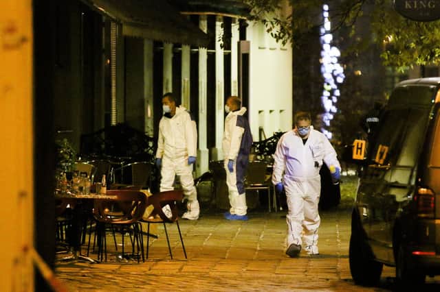Three people investigate at the scene following last night's terror attack.