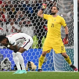 England forward Marcus Rashford reacts after missing his penalty during the Euro 2020 shoot-out defeat to Italy (Photo by ANDY RAIN/POOL/AFP via Getty Images)