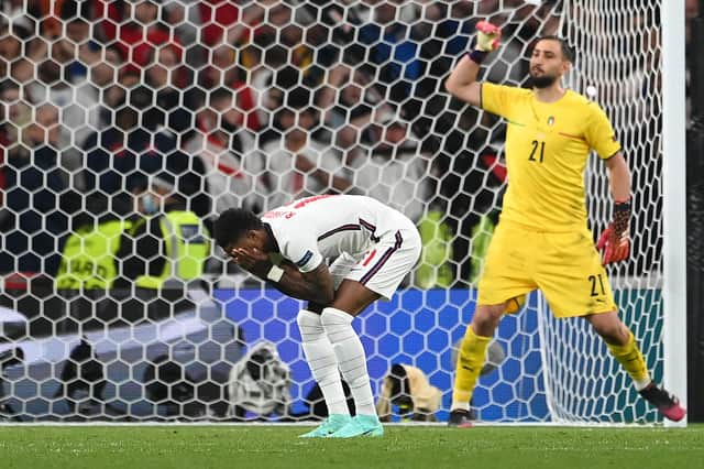 England forward Marcus Rashford reacts after missing his penalty during the Euro 2020 shoot-out defeat to Italy (Photo by ANDY RAIN/POOL/AFP via Getty Images)