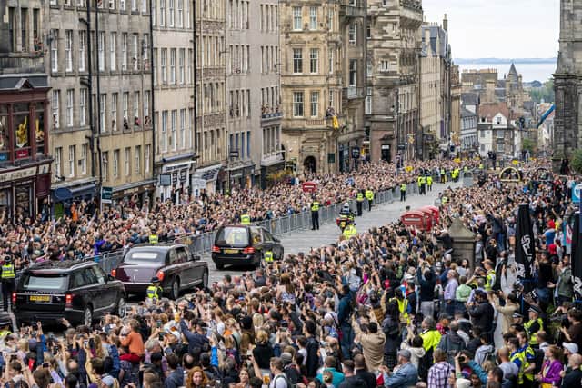 The hearse carrying the coffin of Queen Elizabeth II, draped with the Royal Standard of Scotland, passes down the Royal Mile, Edinburgh, on the journey from Balmoral to the Palace of Holyroodhouse