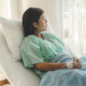 A woman dealing with miscarriage concerns sits on a hospital bed