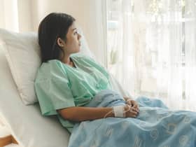 A woman dealing with miscarriage concerns sits on a hospital bed