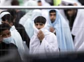 Migrant men wrapped in a blankets are kept behind barriers at the Manston airfield migrant processing centre during a visit by home secretary Suella Braverman. Picture: Dan Kitwood/Getty Images