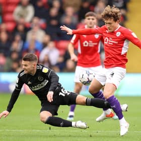Callum Styles of Barnsley is challenged by Oliver Norwood of Sheffield United.