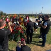 Journalists use their smartphones to take pictures and videos of the grave of Wagner private mercenary group military commander Dmitry Utkin, who was killed in a private jet crash in the Tver region last week, alongside the group's leader, Yevgeny Prigozhin.