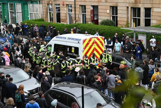 Activists chanting 'let them go' are blocking the path of an immigration enforcement van