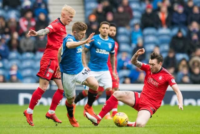 Rangers' Greg Docherty takes on Falkirk's Jordan McGhee (R) and Craig Sibbald (L) in the last meeting of the sides in 2018 at Ibrox.