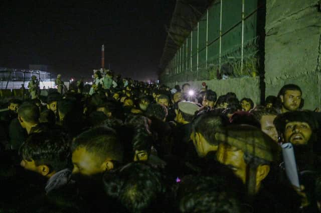 Crowds of people wait outside the foreign military-controlled part of Kabul airport on Sunday night, hoping to flee the country following the Taliban's military takeover of Afghanistan (Picture: Wakil Kohsar/AFP via Getty Images)