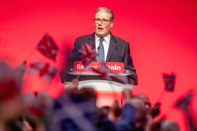 People wave flags as Prime Minister Sir Keir Starmer delivers his keynote speech during the Labour Party Conference (Picture: Danny Lawson/PA Wire)