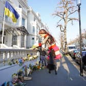 Little Amal, a 3.5-metre partly-animatronic, refugee puppet, lays flowers outside the Ukrainian Embassy in London