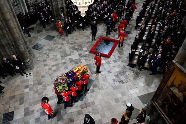 LONDON, ENGLAND - SEPTEMBER 19: The coffin of Queen Elizabeth II with the Imperial State Crown resting on top is carried by the Bearer Party into Westminster Abbey during the State Funeral of Queen Elizabeth II on September 19, 2022 in London, England. Elizabeth Alexandra Mary Windsor was born in Bruton Street, Mayfair, London on 21 April 1926. She married Prince Philip in 1947 and ascended the throne of the United Kingdom and Commonwealth on 6 February 1952 after the death of her Father, King George VI. Queen Elizabeth II died at Balmoral Castle in Scotland on September 8, 2022, and is succeeded by her eldest son, King Charles III.  (Photo by Gareth Cattermole/Getty Images)
