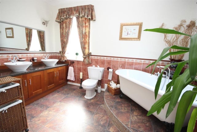 An elegant room with a his and hers contemporary wash hand basins set into a vanity unit which also provides storage space.