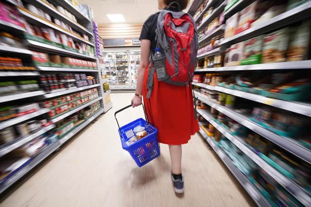 A shopper walking through the aisle of a Tesco supermarket. The UK Government wants to encourage supermarket to place a price cap on basic food items such as bread. Picture: Yui Mok/PA Wire