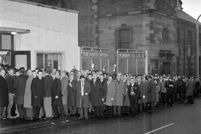 Employees of the North British Rubber Company queue for their wages in December 1965.