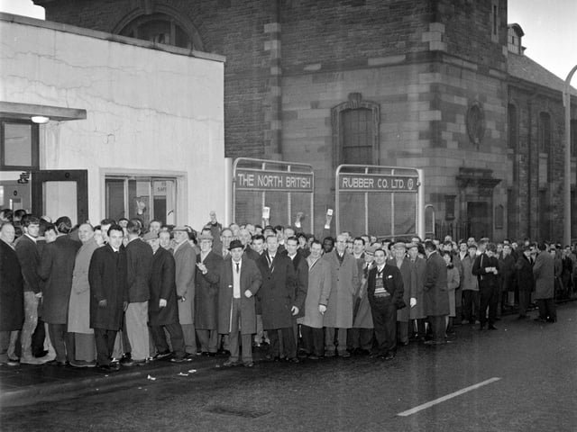 Employees of the North British Rubber Company queue for their wages in December 1965.