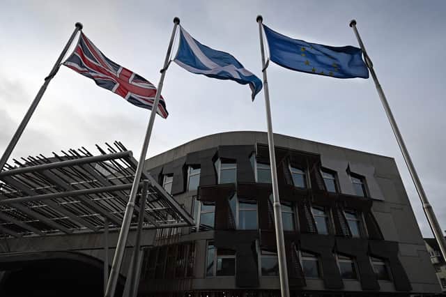 The Union Flag, Saltire of Scotland and EU flag fly outside the entrance to the Scottish Parliament building (Picture: Andy Buchanan/AFP via Getty Images)