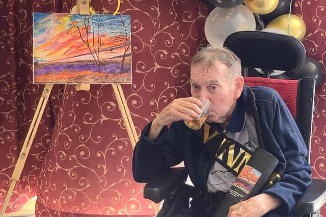 John Picken (91) enjoys a dram of the whisky alongside his winning artwork