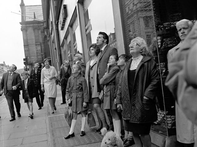 North Bridge in Edinburgh is closed to traffic when a crane delivers a steel beam, part of Patrick Thomson's new escalators, in August 1971. Pedestrians stop to watch.