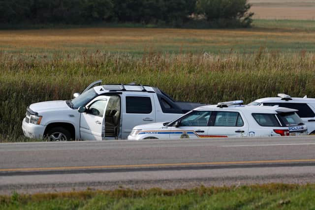 Royal Canadian Mounted Police vehicles are seen next to a pickup truck at the scene where suspect Myles Sanderson was snared. (Photo by LARS HAGBERG/AFP via Getty Images)