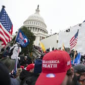 Supporters of President Donald Trump climb on an inauguration platform on the West Front of the U.S. Capitol on Wednesday, Jan. 6, 2021, in Washington. (AP Photo/Jose Luis Magana)