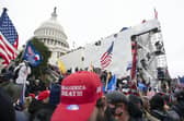 Supporters of President Donald Trump climb on an inauguration platform on the West Front of the U.S. Capitol on Wednesday, Jan. 6, 2021, in Washington. (AP Photo/Jose Luis Magana)