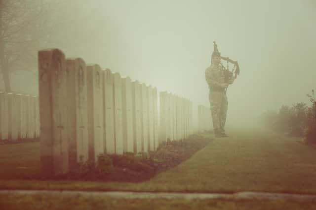 Corporal Stuart Gillies of The 2nd Battalion The Royal Regiment of Scotland practices his bagpipes in Loos British Cemetery during a rehearsal for a re-burial ceremony  on March 13, 2014 in Loos-en-Gohelle, France. Almost 100 years after they were killed in action in the World War One battle of Loos in 1915, twenty British soldiers will be re-interred in the Commonwealth War Graves Commission Loos British Cemetery in Northern France. (Photo by Peter Macdiarmid/Getty Images)