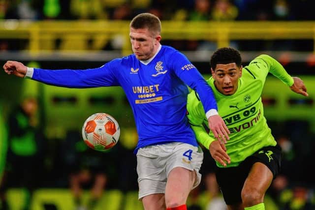 Rangers' English midfielder John Lundstram (L) holds off Borussia Dortmund's Jude Bellingham during the team's last match in Germany in February. (Photo by SASCHA SCHUERMANN/AFP via Getty Images)