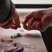 A drug user prepares heroin before injecting. Picture: Jeff J Mitchell/Getty Images