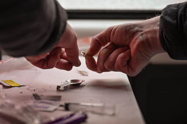 A drug user prepares heroin before injecting. Picture: Jeff J Mitchell/Getty Images