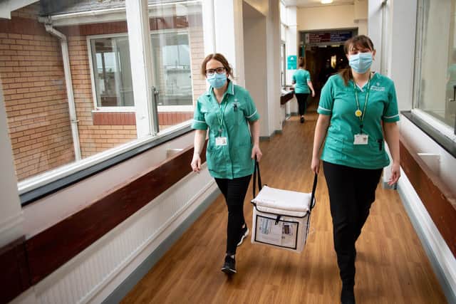 Pharmacists transport a cooler containing the Moderna vaccine, at the West Wales General Hospital in Carmarthen, ahead of delivery of the first Moderna vaccinations in the UK.