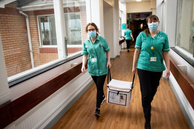 Pharmacists transport a cooler containing the Moderna vaccine, at the West Wales General Hospital in Carmarthen, ahead of delivery of the first Moderna vaccinations in the UK.