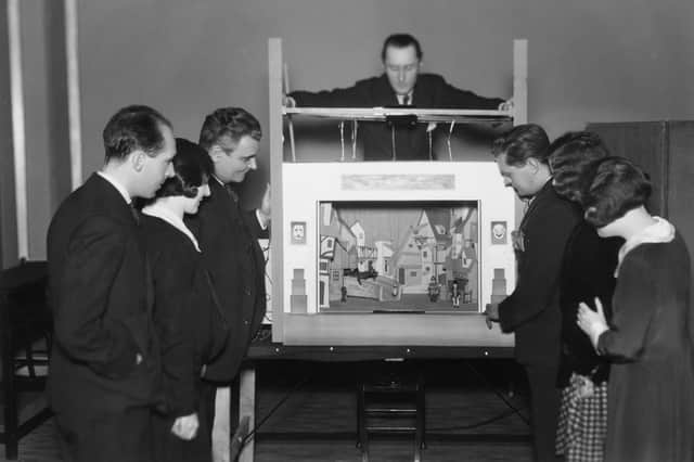 Members of the BBC's children's department watch a demonstration of a model box for the programme Toy Town in 1930 (Picture: Sasha/Hulton Archive/Getty Images)