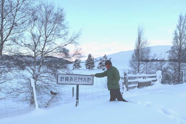 Simon Blackett, who is 6ft7in, knee-deep in snow next to the Braemar sign picture: supplied