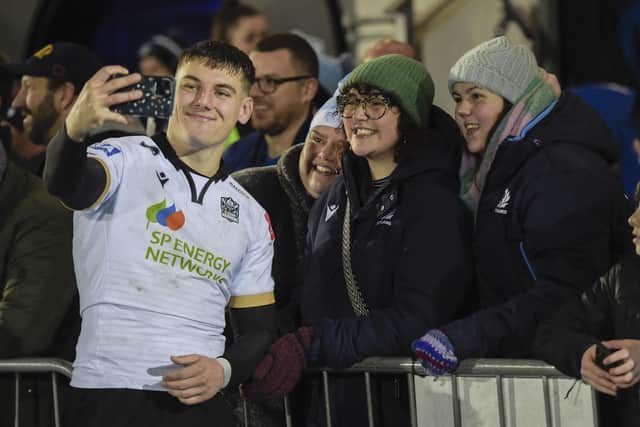Glasgow Warriors' Tom Jordan takes a picture with fans after the win over Edinburgh.