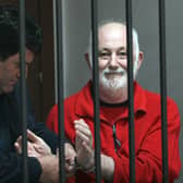 A Police officer remove the handcuffs from Britton David Brown, 57, before the verdict in court, where he was sentenced him to 20 years in jail for sexually abusing minors, in Tirana on November 19, 2008. Picture: GENT SHKULLAKU/AFP via Getty Images