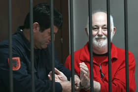 A Police officer remove the handcuffs from Britton David Brown, 57, before the verdict in court, where he was sentenced him to 20 years in jail for sexually abusing minors, in Tirana on November 19, 2008. Picture: GENT SHKULLAKU/AFP via Getty Images