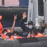 Migrants gesture as they arrive in Dover aboard a Border Force vessel after being intercepted while crossing the English Channel from France in small boats (Picture: Peter Summers/Getty Images)