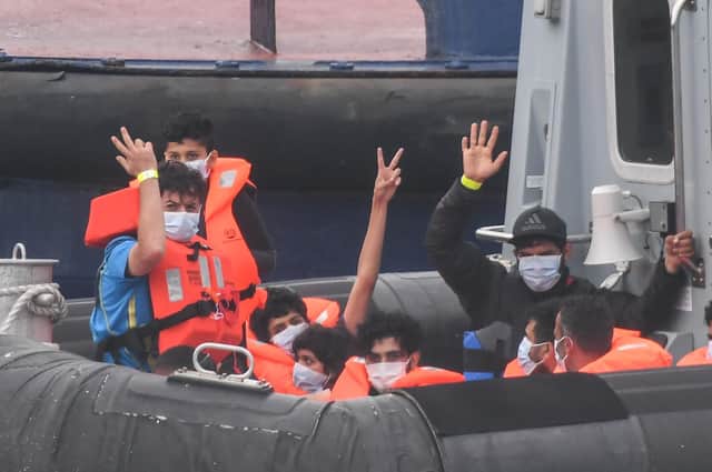 Migrants gesture as they arrive in Dover aboard a Border Force vessel after being intercepted while crossing the English Channel from France in small boats (Picture: Peter Summers/Getty Images)