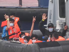 Migrants gesture as they arrive in Dover aboard a Border Force vessel after being intercepted while crossing the English Channel from France in small boats (Picture: Peter Summers/Getty Images)