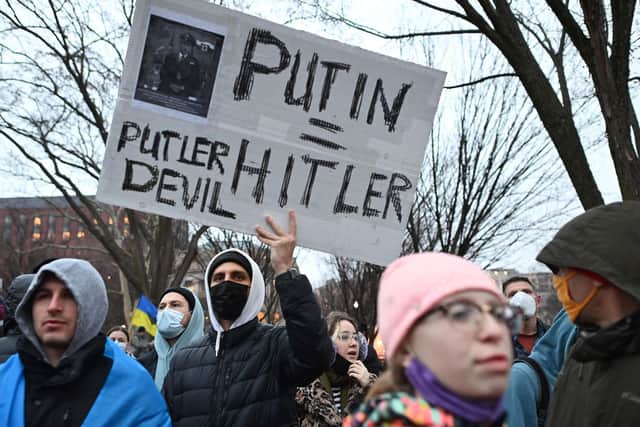 A demonstrator holds a placard as people gather in Lafayette Square to protest Russia's invasion of Ukraine in Washington, DC. Photo: MANDEL NGAN/AFP via Getty Images.