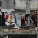 A Palestinian woman hangs laundry in a heavily damaged building in Jabalia in the northern Gaza Strip (Picture: Bashar Taleb/AFP via Getty Images)