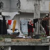 A Palestinian woman hangs laundry in a heavily damaged building in Jabalia in the northern Gaza Strip (Picture: Bashar Taleb/AFP via Getty Images)