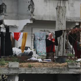 A Palestinian woman hangs laundry in a heavily damaged building in Jabalia in the northern Gaza Strip (Picture: Bashar Taleb/AFP via Getty Images)