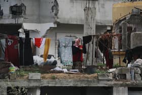 A Palestinian woman hangs laundry in a heavily damaged building in Jabalia in the northern Gaza Strip (Picture: Bashar Taleb/AFP via Getty Images)