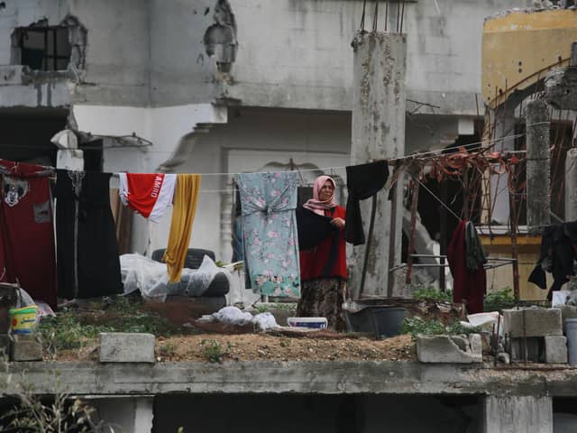 A Palestinian woman hangs laundry in a heavily damaged building in Jabalia in the northern Gaza Strip (Picture: Bashar Taleb/AFP via Getty Images)