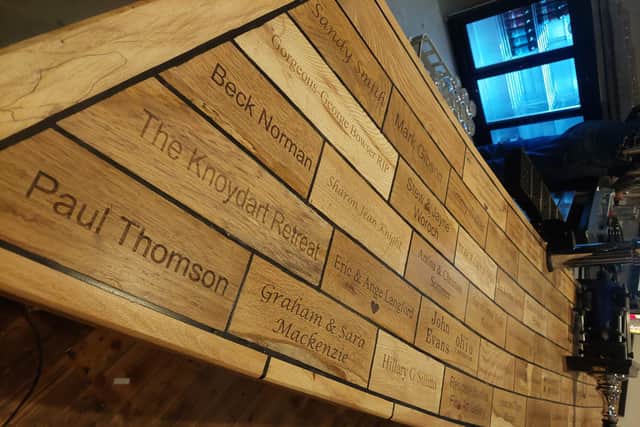 The new bar top made with Knoydart wood and which has names from people who helped in the fundraising effort carved into it (pic: Mark Harris)