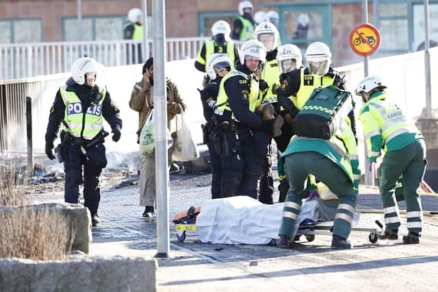 Police and ambulance personnel carry an injured man who was shot in the leg during rioting in Norrkoping, Sweden on April 17th. Photo: Stefan JERREVANG / various sources / AFP) / Sweden OUT via Getty Images.