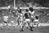 Gordon McQueen powers home a header to set Scotland up for a famous 2-1 victory over England at Wembley in 1977. Pic: Denis Straughan.