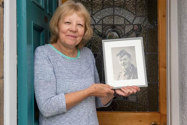 Diane Chisholm holds a picture of her father, Colin Chisholm, on the 80th anniversary of his capture at St Valery.