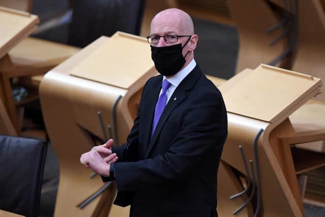 Deputy First Minister John Swinney, wearing a face mask, arrives in the chamber to update MSPs at the Scottish Parliament in Holyrood, Edinburgh.